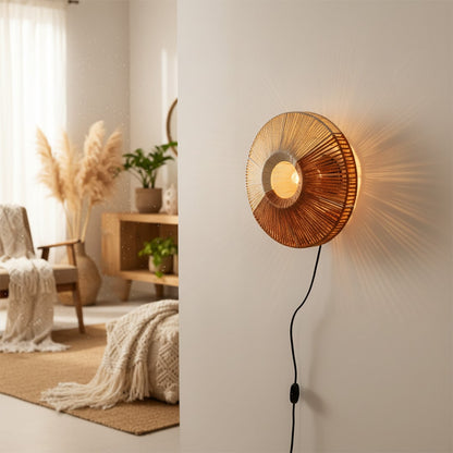 Lifestyle image of woven metal wall light in warm gold tone mounted on living room wall casting cozy ambient glow.