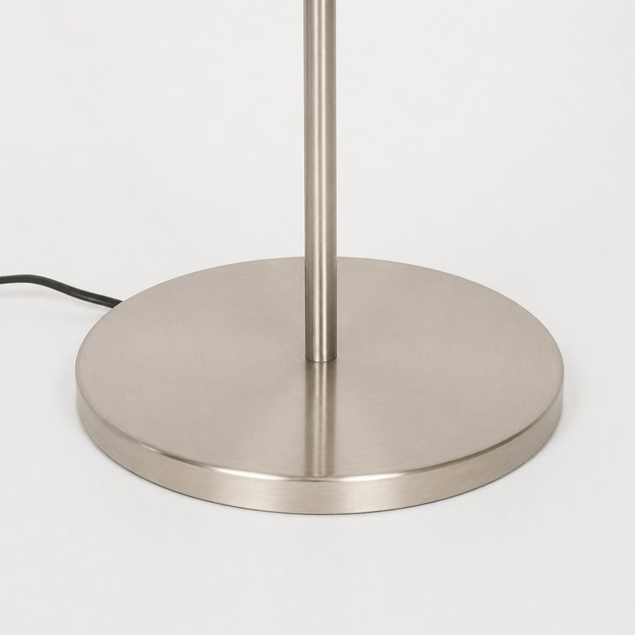 Closeup image of linear silver metal floor lamp base for elegant living room decor styling and modern home lighting setup.