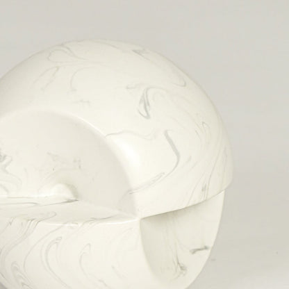 Table decor object in white marble finish with smooth rounded form and subtle grey veining shown in close up highlighting its sculptural modern design and matte texture