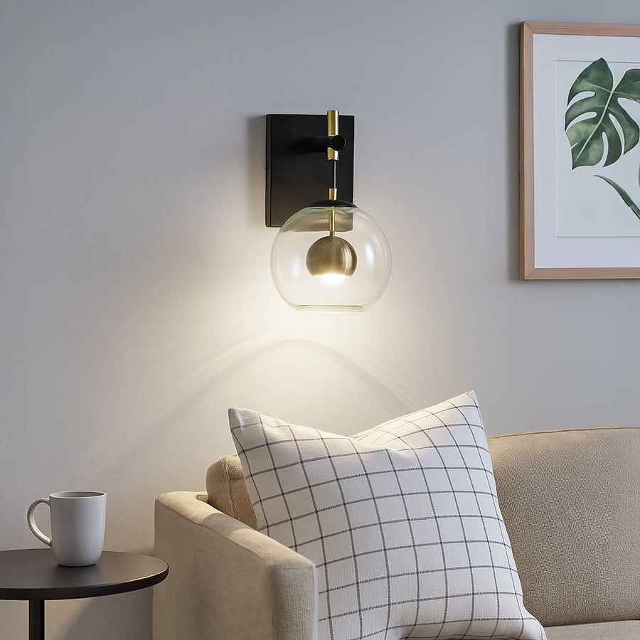 Modern black metal wall light lifestyle image with glass globe shade for cozy living room ambient lighting.