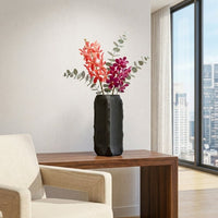 Dark grey ceramic flower vase with textured finish placed on wooden table for modern living room decor styling.