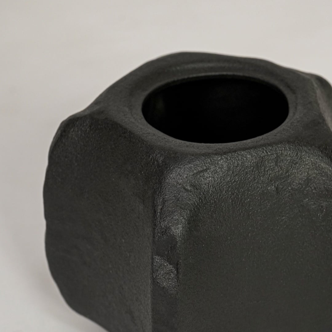 Closeup of black ceramic planter with sculpted matte texture for elegant tabletop and shelf decor styling ideas.