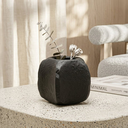 Black ceramic planter with textured finish styled with dried blooms for elegant modern home decor placement.