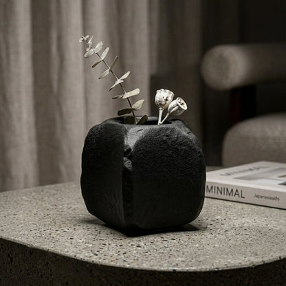 Black ceramic planter with textured finish styled with dried blooms for elegant modern home decor placement.