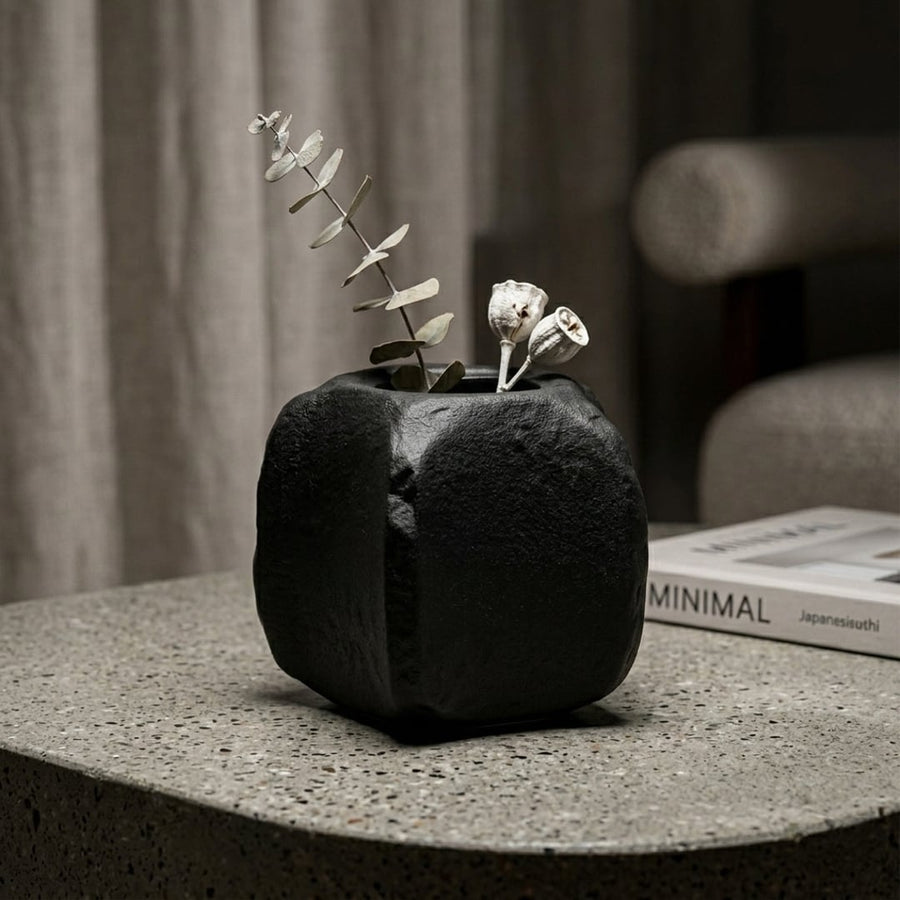 Black ceramic planter with textured finish styled with dried blooms for elegant modern home decor placement.