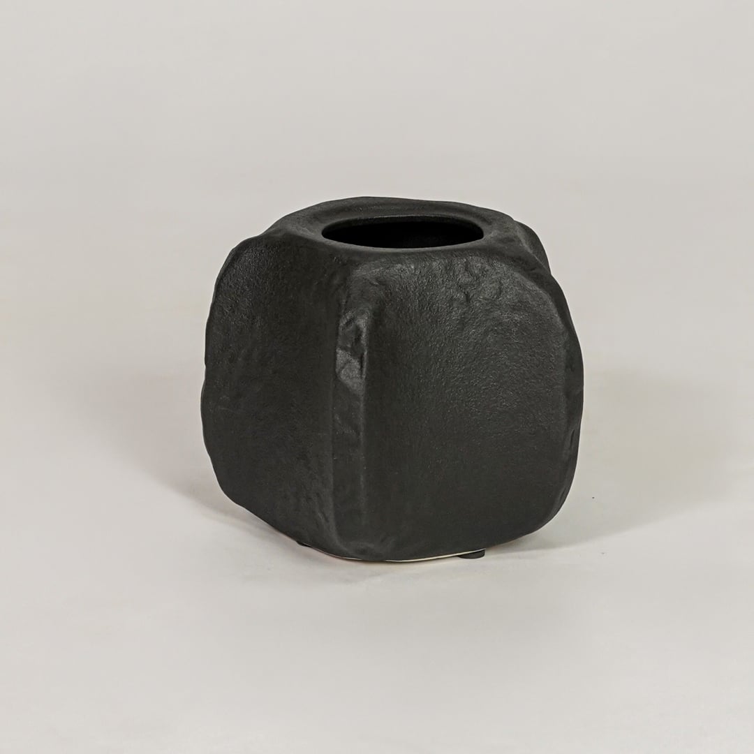 Black ceramic decorative planter with sculpted matte finish for modern tabletop shelf and console decor placement.
