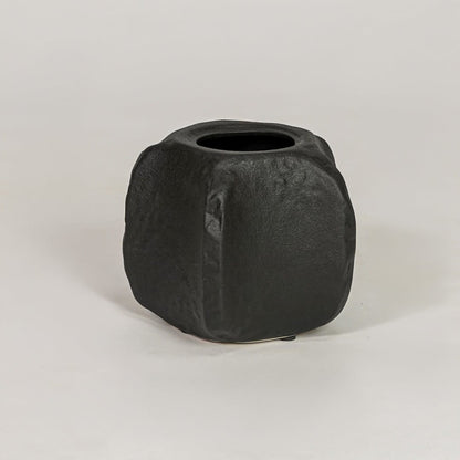 Black ceramic decorative planter with sculpted matte finish for modern tabletop shelf and console decor placement.