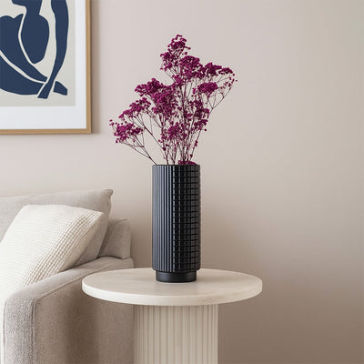 Black textured ceramic vase styled in a modern interior setting ideal for living rooms shelves and elegant contemporary home decor.
