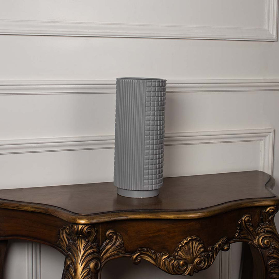 Tall grey ceramic vase with embossed grid design displayed on a plain white background highlighting its smooth finish.
