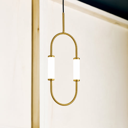 A modern pendant light with a gold-toned metal frame in an oval shape, featuring two cylindrical white frosted glass shades, shown hanging against a minimalist off-white wall.