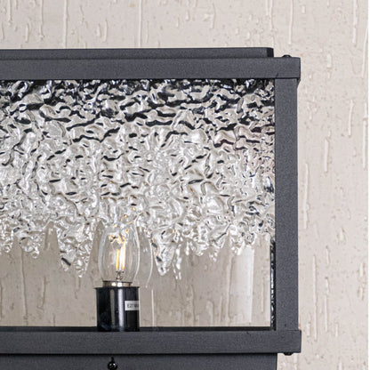 Close view highlighting smooth textured glass pattern and fine black metal structure of designer pillar light.