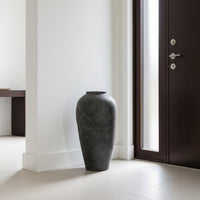Black textured floor vase placed near doorway for stylish modern home decor styling.