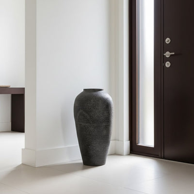 Black textured floor vase placed near doorway for stylish modern home decor styling.
