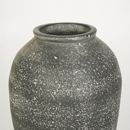 Closeup image of grey ceramic rustic vase for modern tabletop decor styling with textured matte finish.