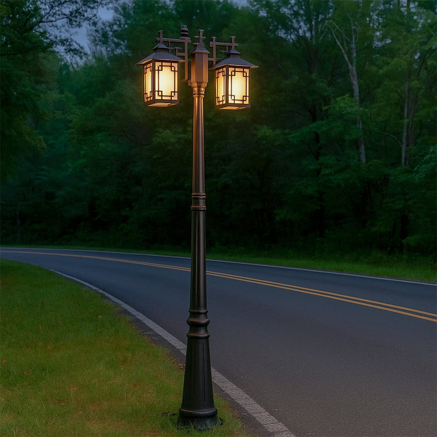 Decorative outdoor street lamp with dual glowing lights styled beside roadway for luxury decor ambiance.