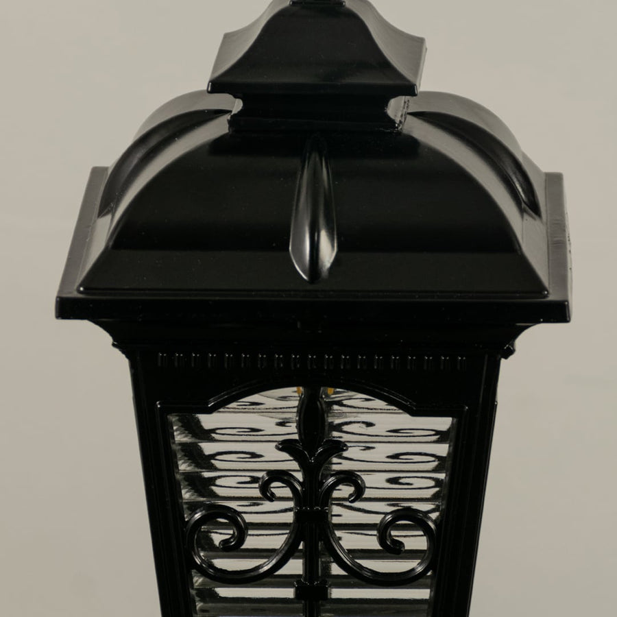A closeup view of the hanging lantern showing the textured glass and ornate metal detailing with the warm glow inside enhancing the overall aesthetic appeal.