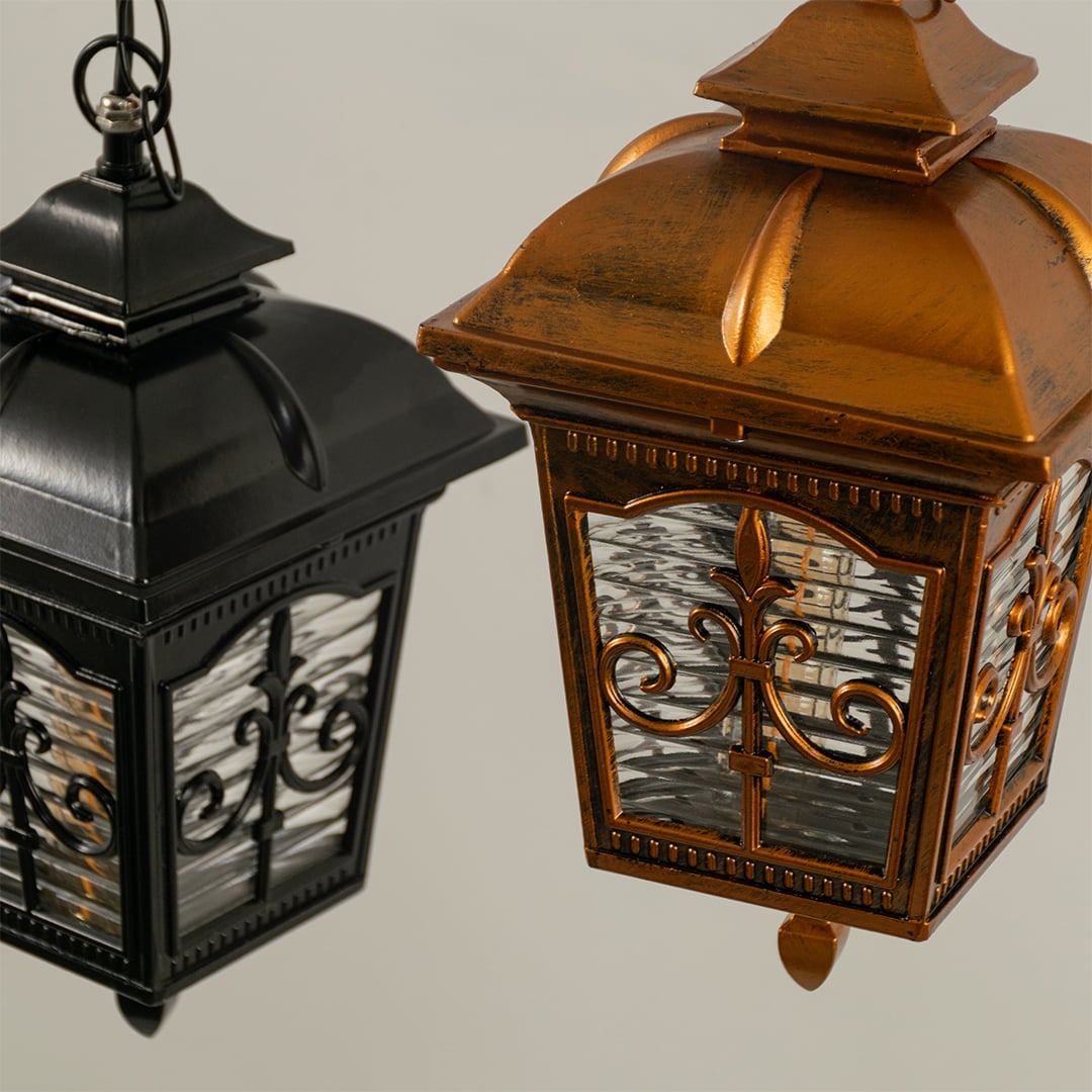 A focused closeup of the lantern highlighting the elegant patterns on the metal frame and the soft inner glow creating a refined decorative appearance.
