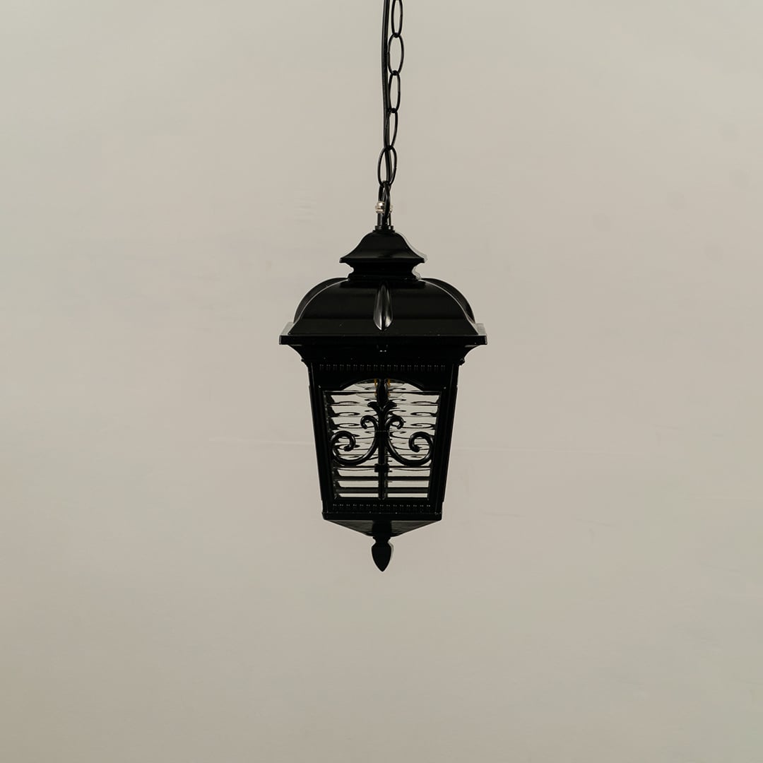 A classic black hanging lantern with the light off shown against a white background highlighting its detailed metal frame and patterned frosted glass panels.