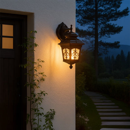 Black metal outdoor wall lantern glowing warmly beside a modern entrance wall creating a cozy nighttime lifestyle look for garden pathways and home exteriors.