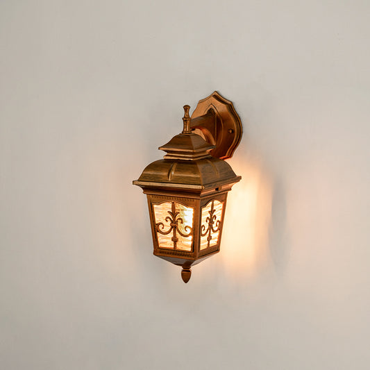 Antique brass outdoor wall light on white background with an ornate lattice glass frame overlay for classic porch decor.