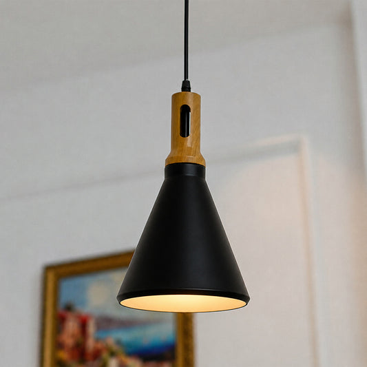 A modern pendant light with a matte black cone-shaped shade, a natural wood neck, and a black cord, shown hanging in a softly lit indoor setting.