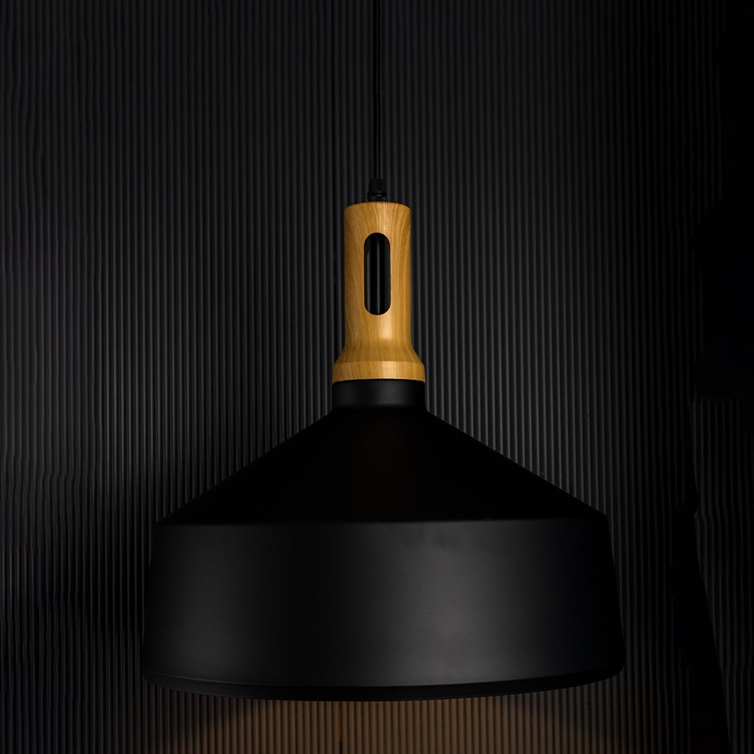 A black pendant light with a wooden top glowing softly against a dark background enhancing its warm light effect and modern sculpted form.