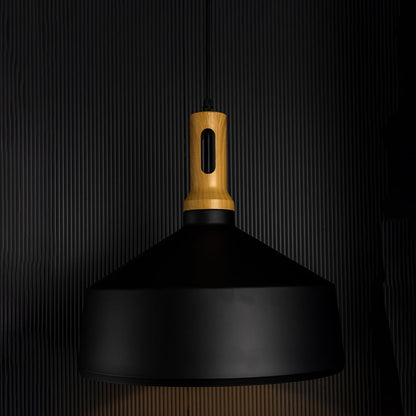 A black pendant light with a wooden top glowing softly against a dark background enhancing its warm light effect and modern sculpted form.