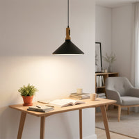 Black metal pendant light suspended above dining table creating warm ambiance and timeless appeal.