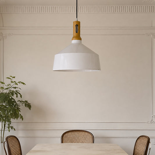 A modern pendant light with a white dome shade and a natural wood neck, hanging in a dining room setting above a table with woven chairs.
