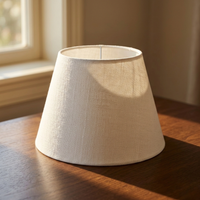 White fabric lamp shade placed on wooden table for elegant modern lighting decor styling ideas.