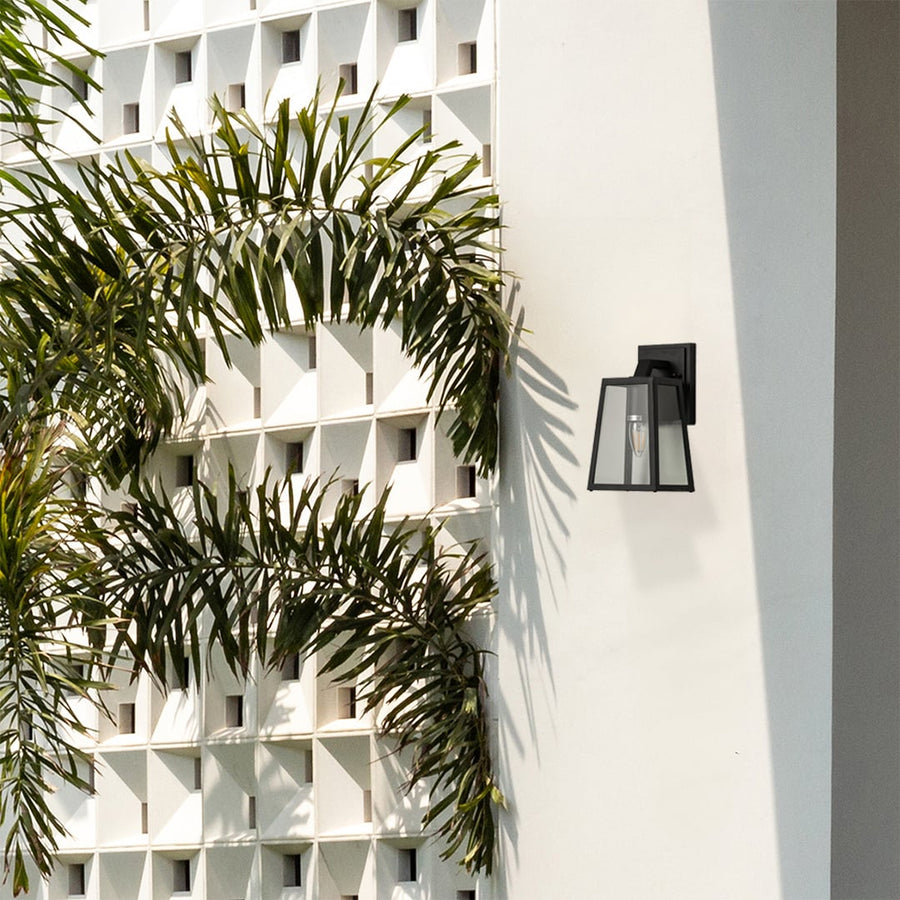 Modern black metal outdoor wall lantern enhancing exterior decor with clear glass sides for bright focused illumination.