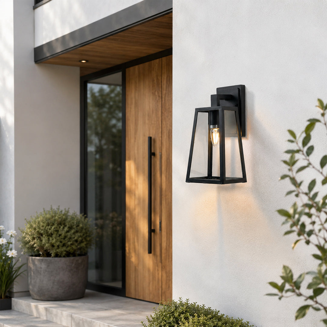 Black metal outdoor wall light lifestyle image beside wooden entry door for elegant exterior lighting decor.