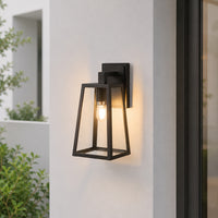 Modern black metal outdoor wall light with clear glass for porch entrance garden and exterior walls with warm lighting.