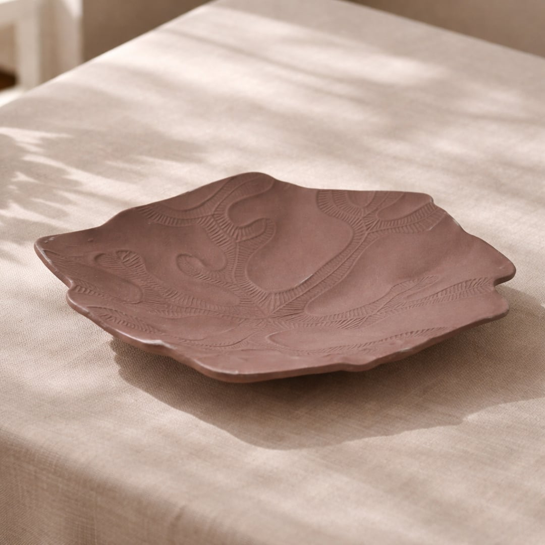 Brown ceramic decorative tray styled on center table enhancing contemporary living room decor.