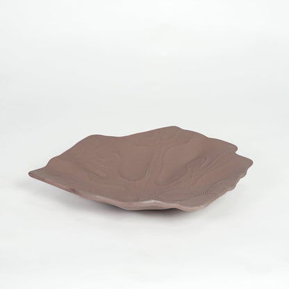 Rustic brown ceramic display platter with sculpted surface and wide design isolated on white background.