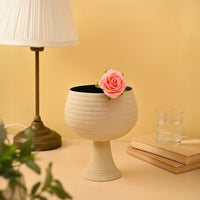 Cream metal pedestal bowl decor placed in a warm modern setting adding an elegant touch to living room tables and shelves.
