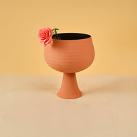Terracotta metal pedestal bowl decor styled in a warm modern room adding an earthy accent to living room tables and shelves.