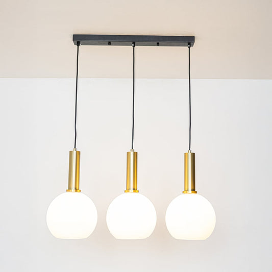 Warm glowing white globe pendant lights with gold holders and adjustable wires displayed against a bright white background for decor styling.