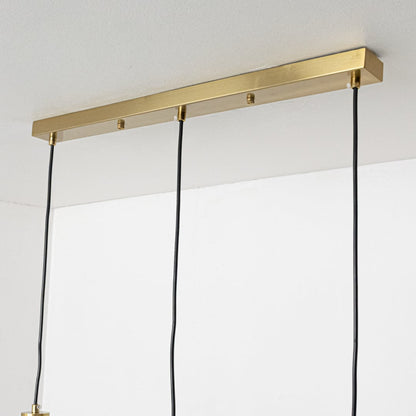 Closeup of gold and white glass pendant light showing smooth glass globe and sleek metal finish.