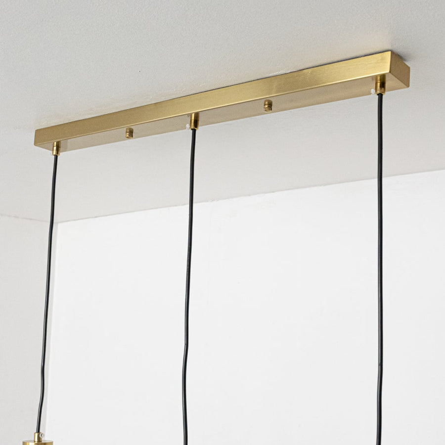 Closeup of gold and white glass pendant light showing smooth glass globe and sleek metal finish.