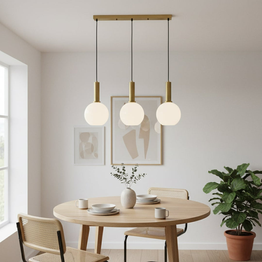 Modern gold and white glass pendant lights adding a clean stylish touch to a bright contemporary room interior.
