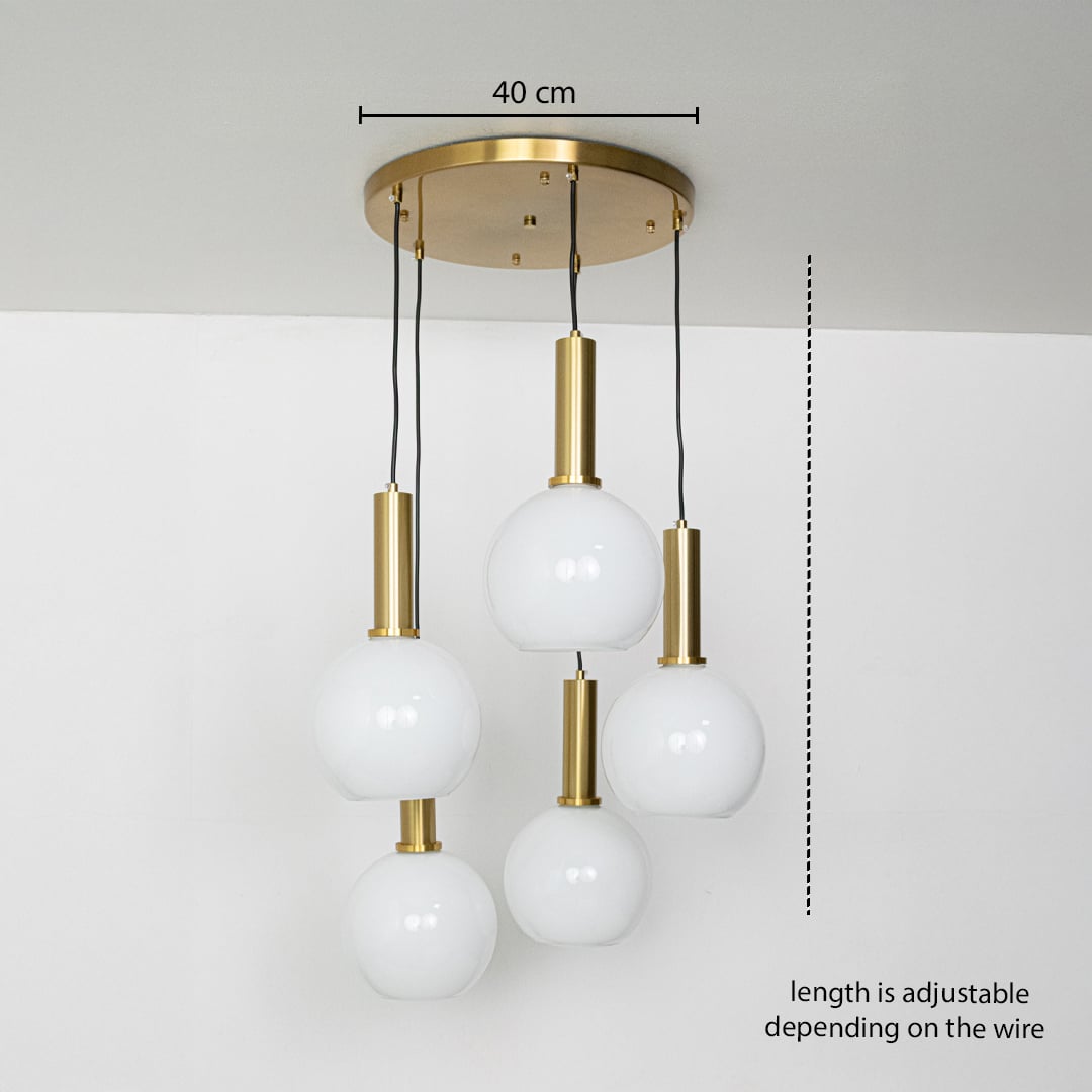 Adjustable five light pendant cluster with white globes and gold metal holders shown with a clear hanging height guide for accurate display.
