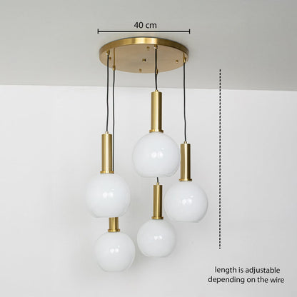 Adjustable five light pendant cluster with white globes and gold metal holders shown with a clear hanging height guide for accurate display.