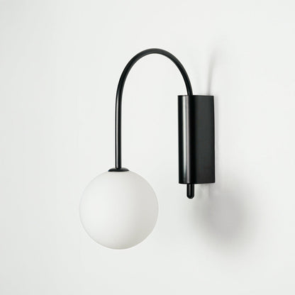 Minimal black wall light with white glass globe shade on clean background perfect for modern home decor lighting.


