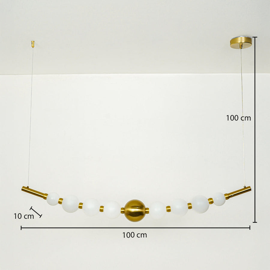 Modern linear pendant light with white glass globes and gold accents suspended on cable 100 cm width 100 cm height 10 cm depth ideal for dining or kitchen lighting.