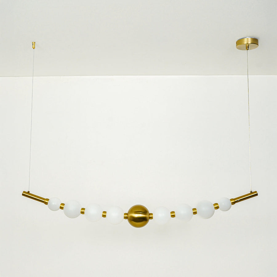 Stylish linear hanging light with multiple white glass globes and gold accents on neutral wall background perfect for modern dining or kitchen lighting.