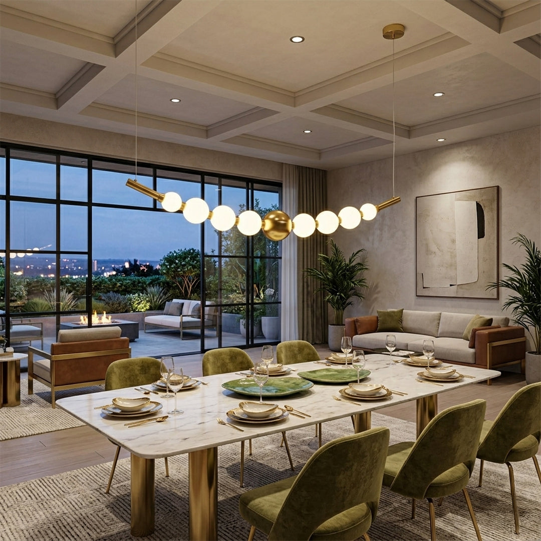 Linear pendant light with white glass globes and gold metal accents installed above dining table in modern luxury dining room interior.