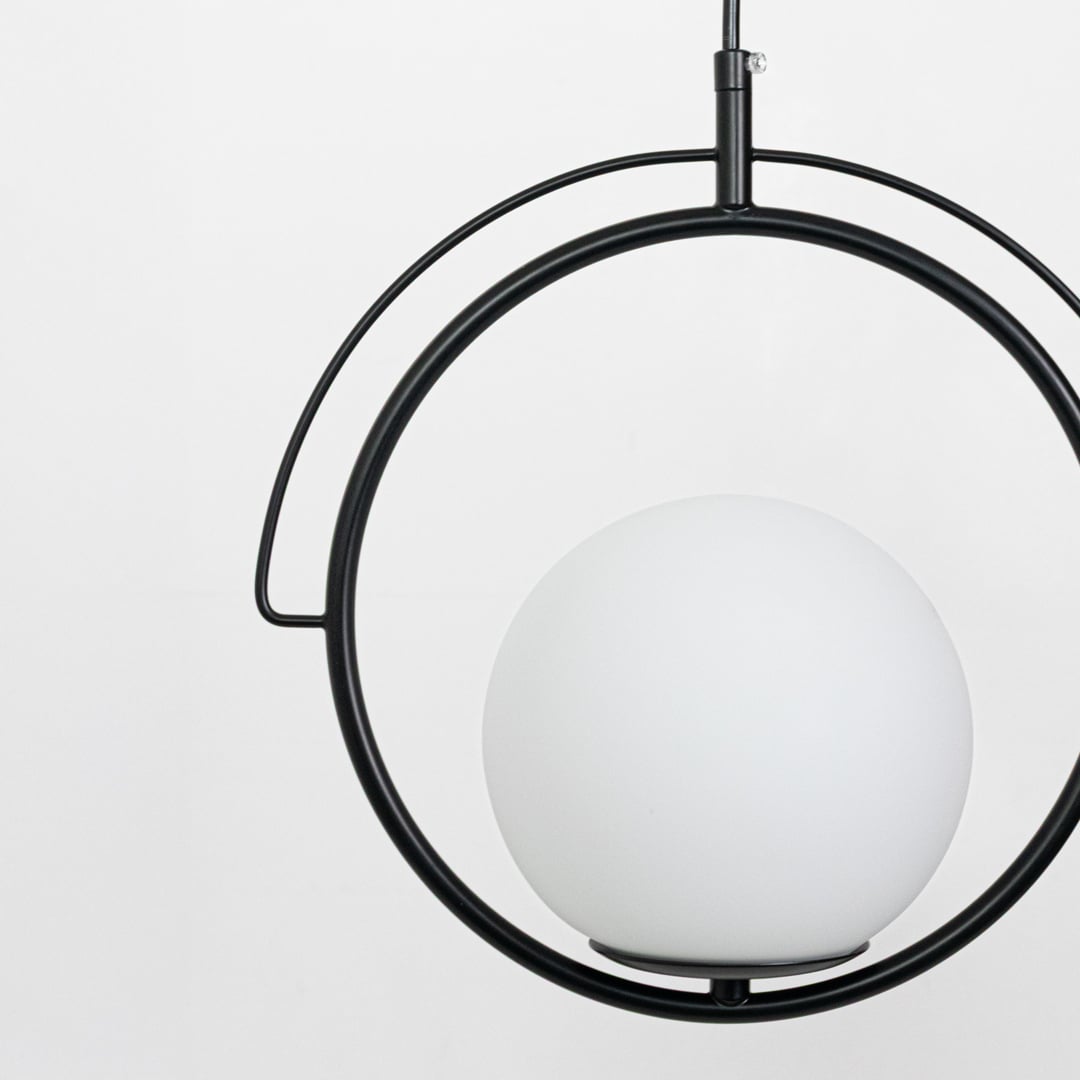 Closeup of black metal and white glass ring pendant light showcasing refined modern detailing.