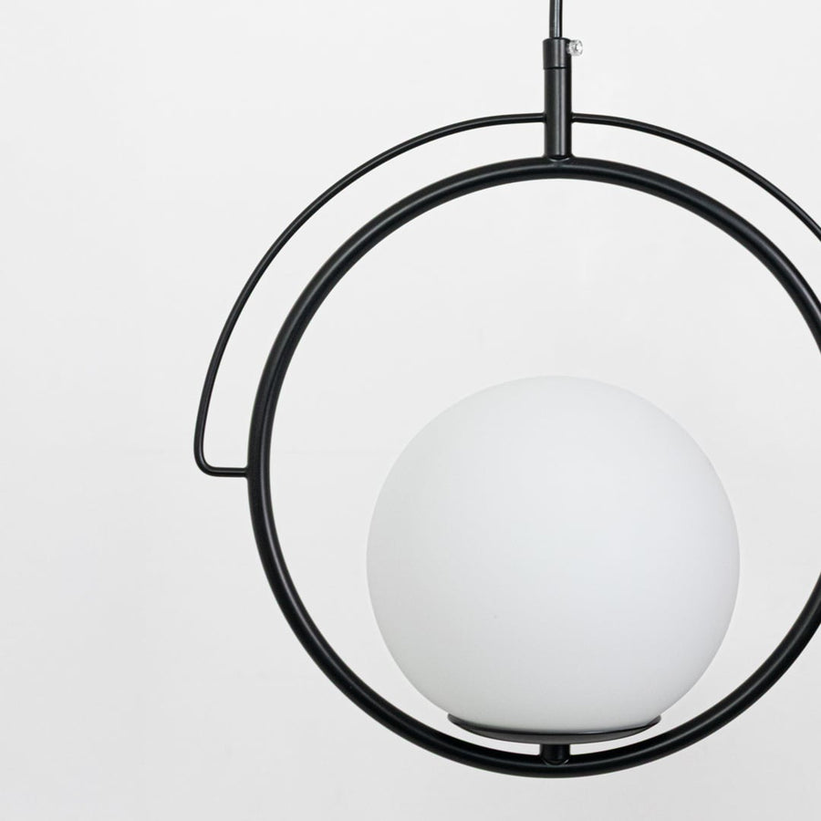 Closeup of black metal and white glass ring pendant light showcasing refined modern detailing.
