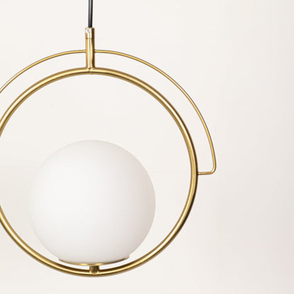 A closeup view of the gold circular pendant light highlighting the smooth white globe and metal frame with detailed texture visible in soft lighting.